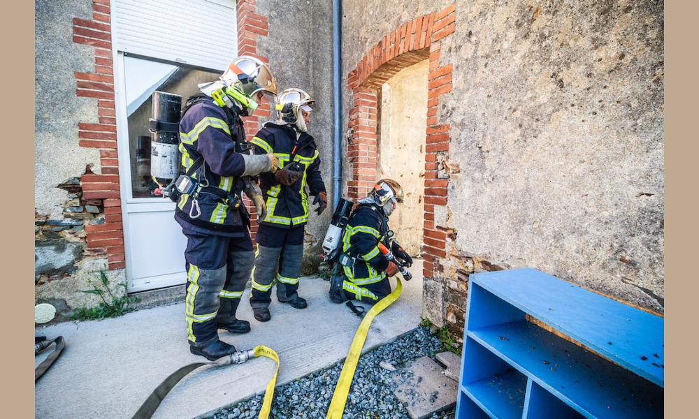 Une équipe, lance en main, se prépare à avancer vers la source du feu, sous les ordres d'un chef d'équipe.