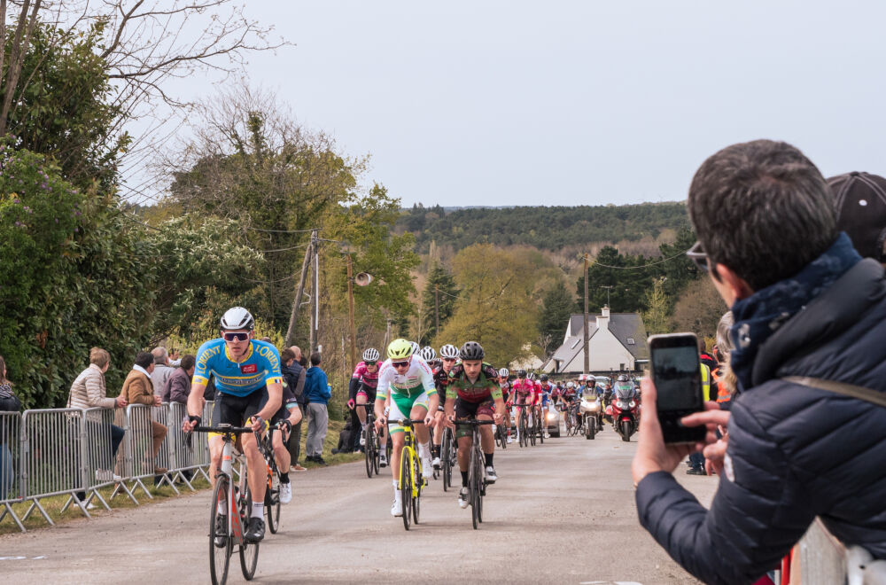 Un membre du public prend une photo des coureurs dans la montée de Saint-Barthélémy, où se tiendra l'arrivée après 5 tours d'une dernières boucle.