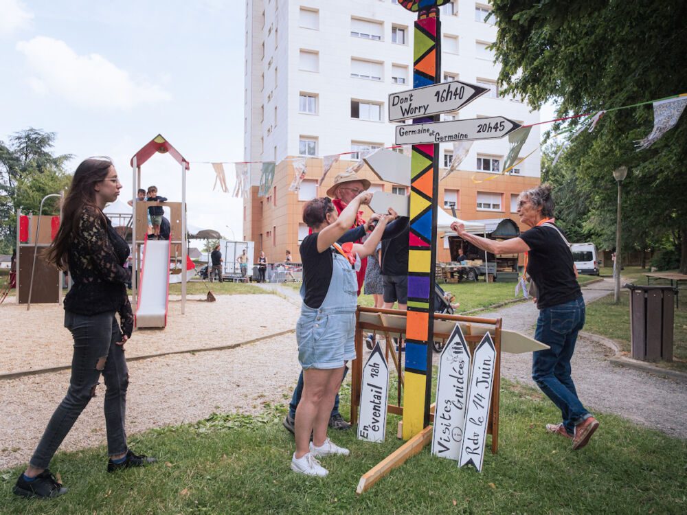 Des bénévoles du festival s'activent pour afficher les panneaux annonçant les prochains spectacles au cœur du Festival.