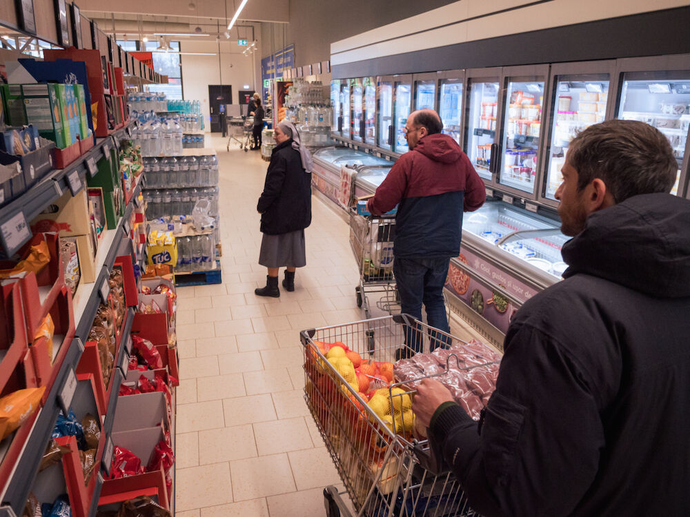 Les volontaires de Ouest-Est font les courses avec Sœur Monica pour constituer les colis de nourriture qu'ils livreront ensuite aux familles.