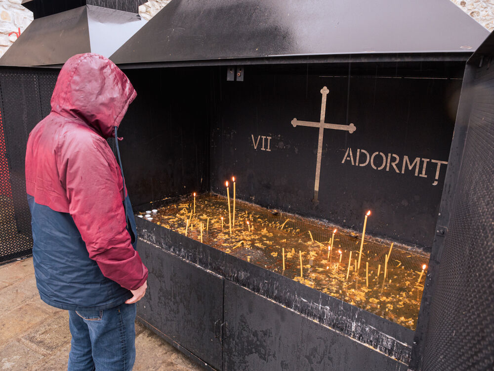 Au monastère de Voronets, un volontaire de Ouest-Est dépose des cierges aux intentions des donateurs de l'association selon la tradition orthodoxe : pour les vivants d'un côté, pour les défunts de l'autres.